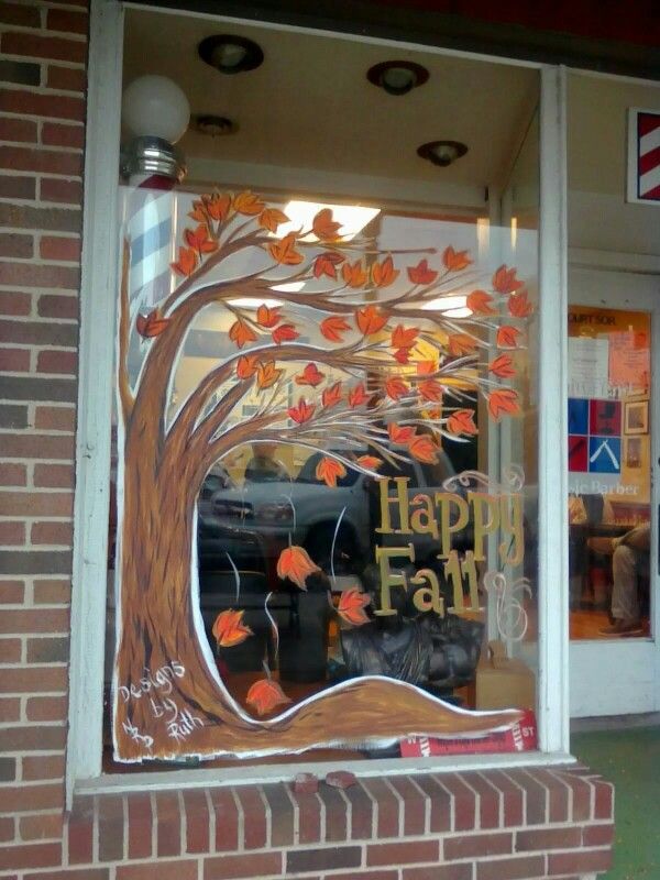 a store front window decorated with fall leaves and the words happy family written on it