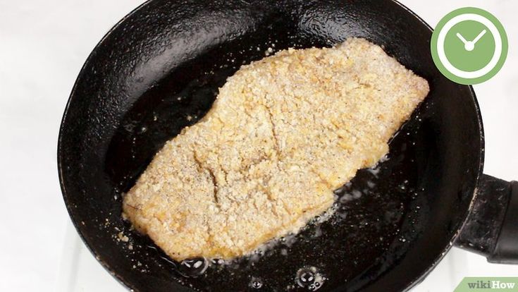 a fish frying in a skillet on top of a stovetop with the words how to cook