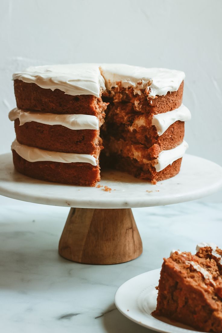 a cake with white frosting is cut into pieces and sits on a plate next to another piece