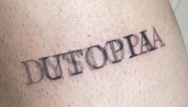 a tattoo with the word dutoppa written on it's side ribcage