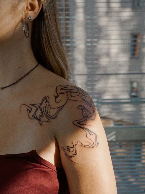 a woman with a tattoo on her shoulder