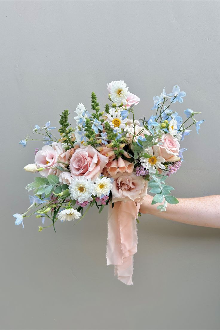 a person holding a bouquet of flowers in their hand