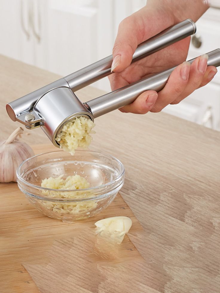 a person is peeling onions in a bowl on a wooden table with an onion peeler