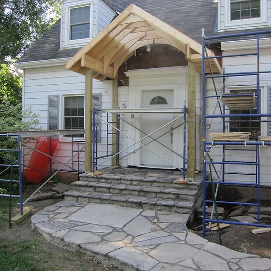 a house being built with scaffolding around the front door and steps leading up to it