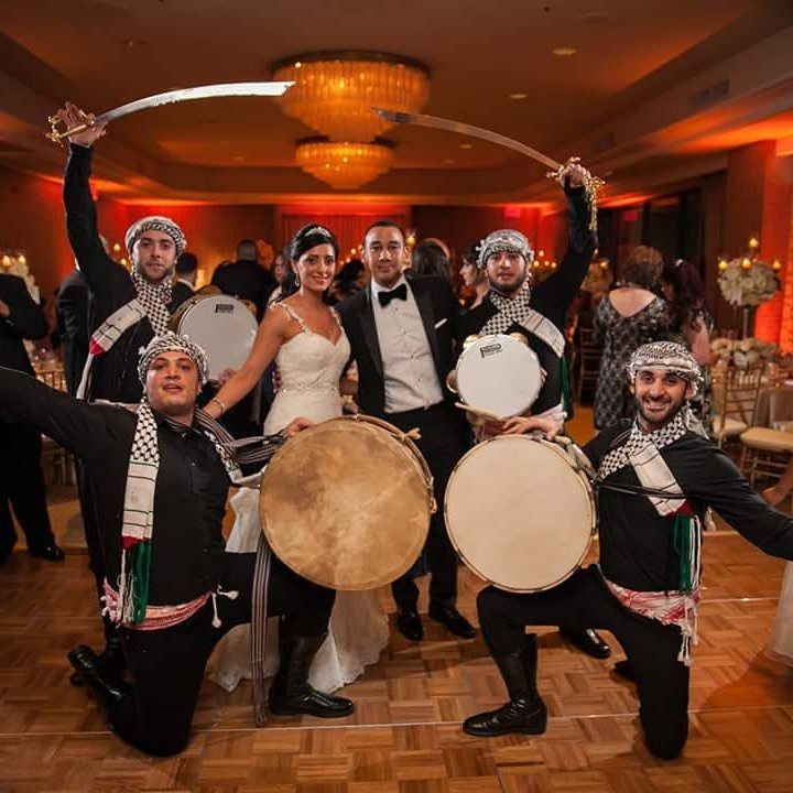 a group of people standing around each other holding drums