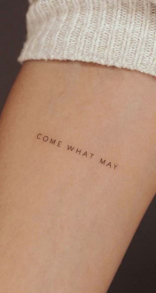 someone with a tattoo on their arm that says,'come what may'in cursive font