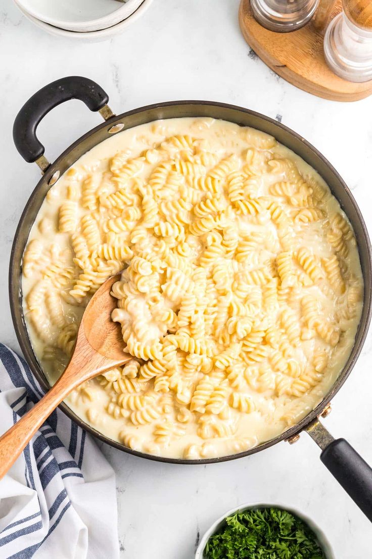 a skillet filled with macaroni and cheese on top of a white counter