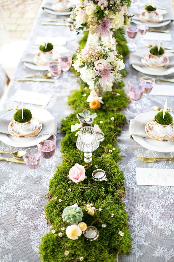 a long table covered in moss and flowers