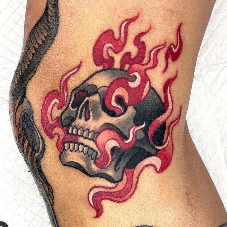 a tattoo with a skull and flames on it