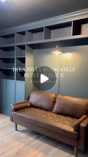 a couch sitting in the middle of a living room next to a book shelf filled with books