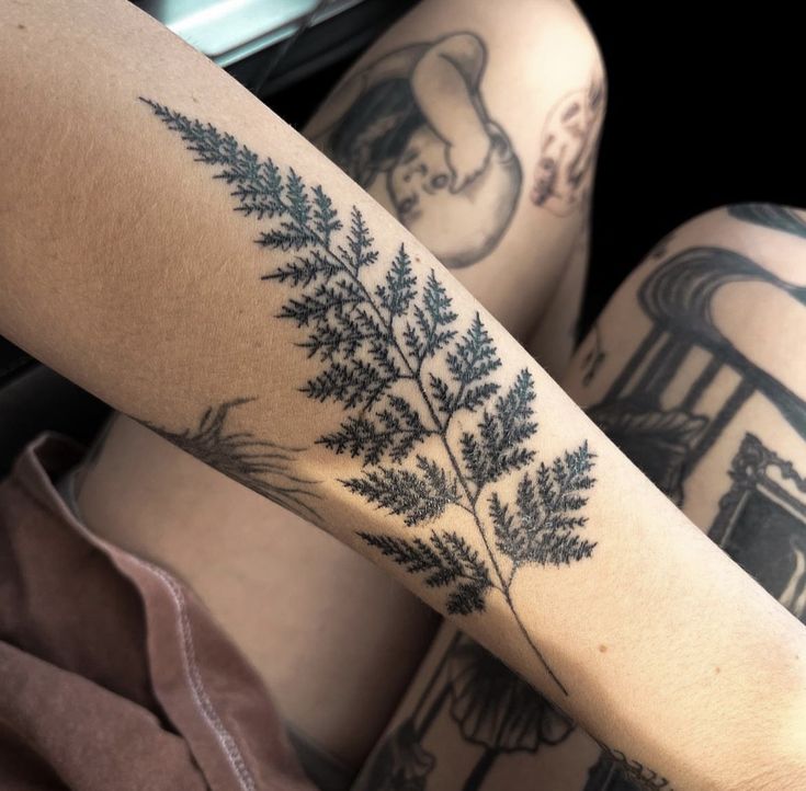 a woman's legs with tattoos on them that have plants growing out of them