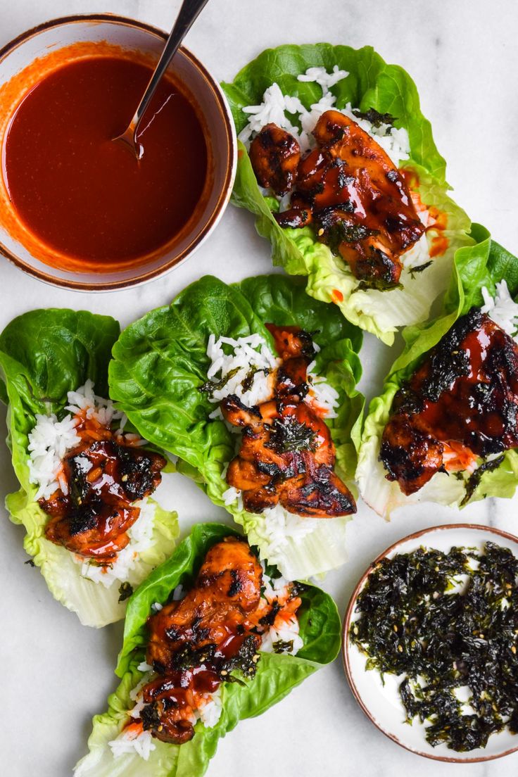 chicken lettuce wraps with sauce on the side and dipping sauce in a bowl