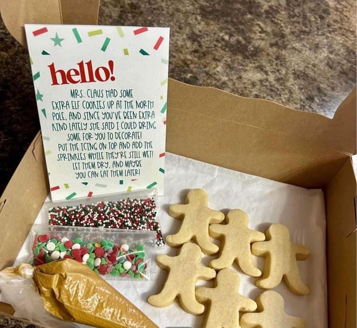 an open box filled with cookies and candies next to a sign that says hello