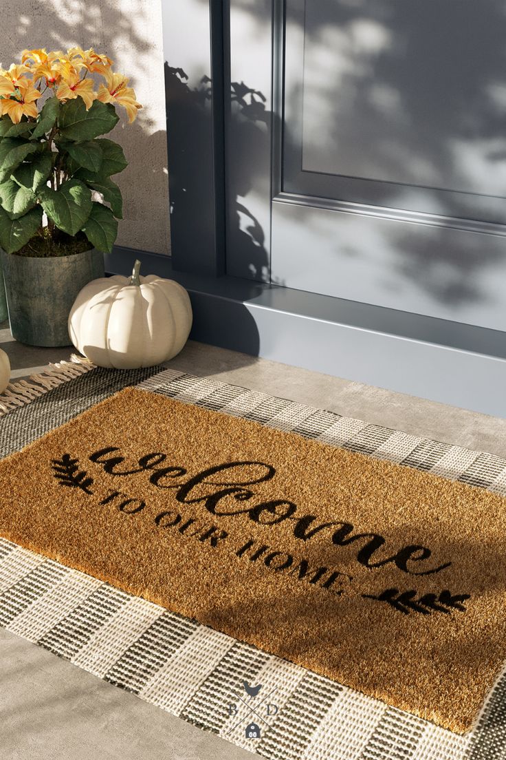 a welcome mat with the words welcome home on it next to a potted plant