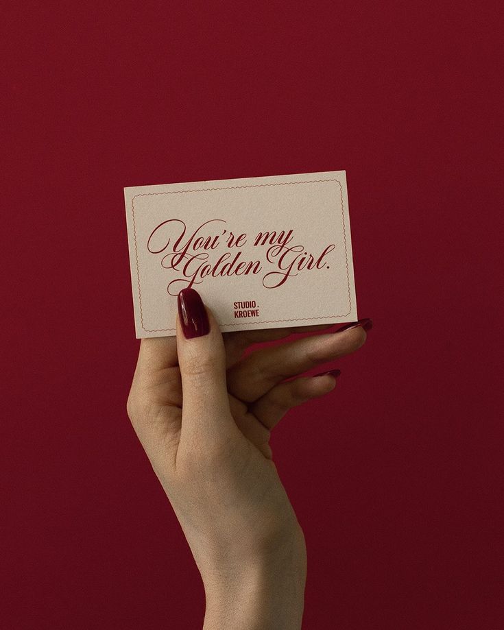 a woman holding up a card with the words you're my golden girl on it