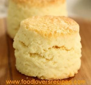 two biscuits sitting on top of a wooden cutting board