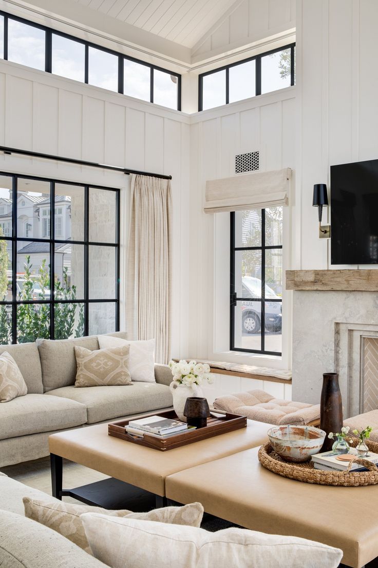 a living room filled with furniture and a flat screen tv mounted on the wall above a fireplace