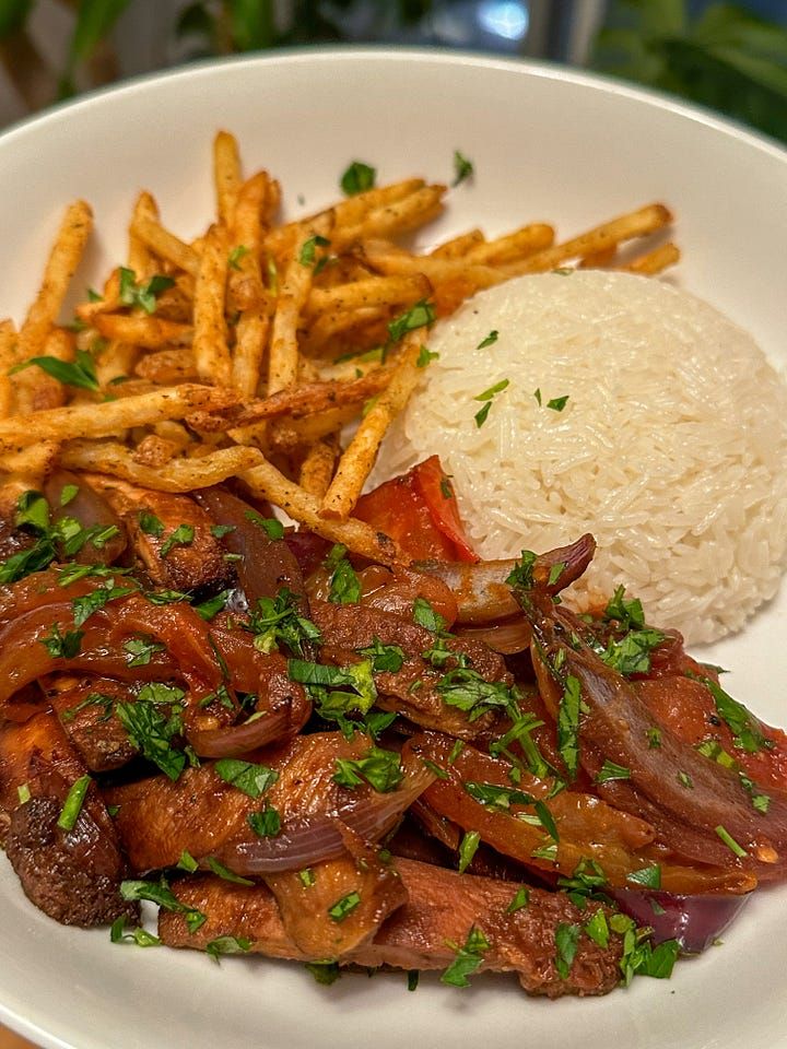 a white plate topped with meat, rice and veggies next to a pile of fries