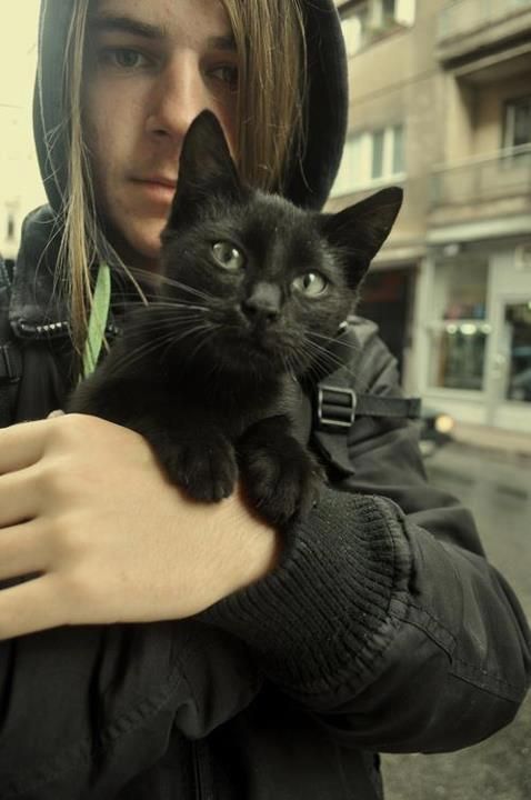 a woman holding a black cat in her arms