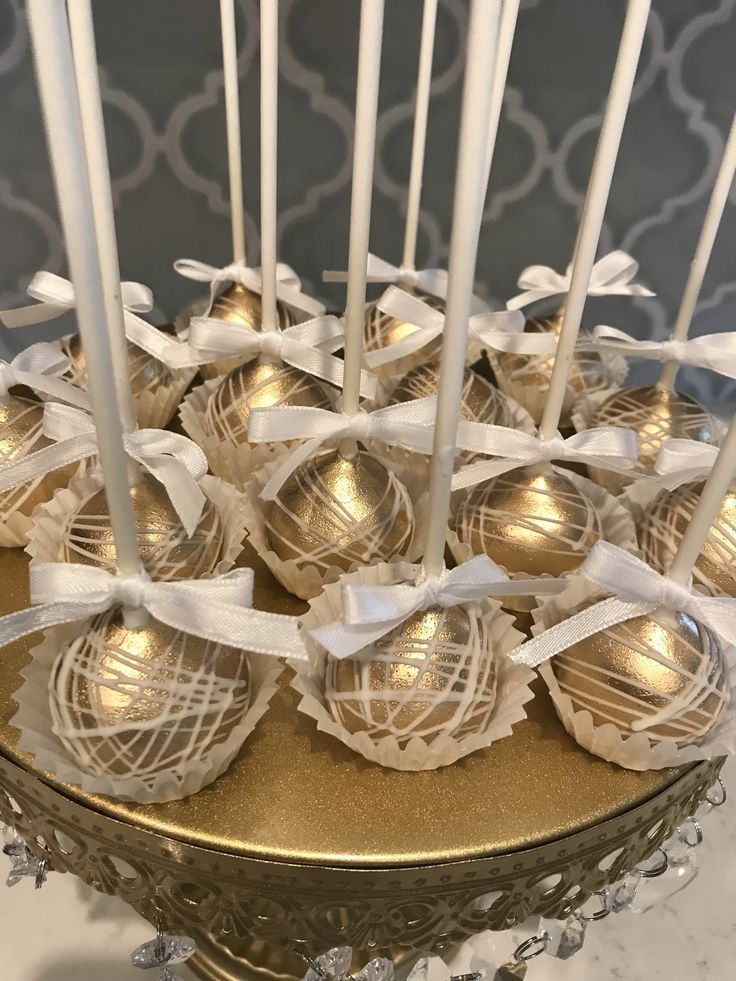 there are many chocolate candies on the plate with white ribbons around them and some candles