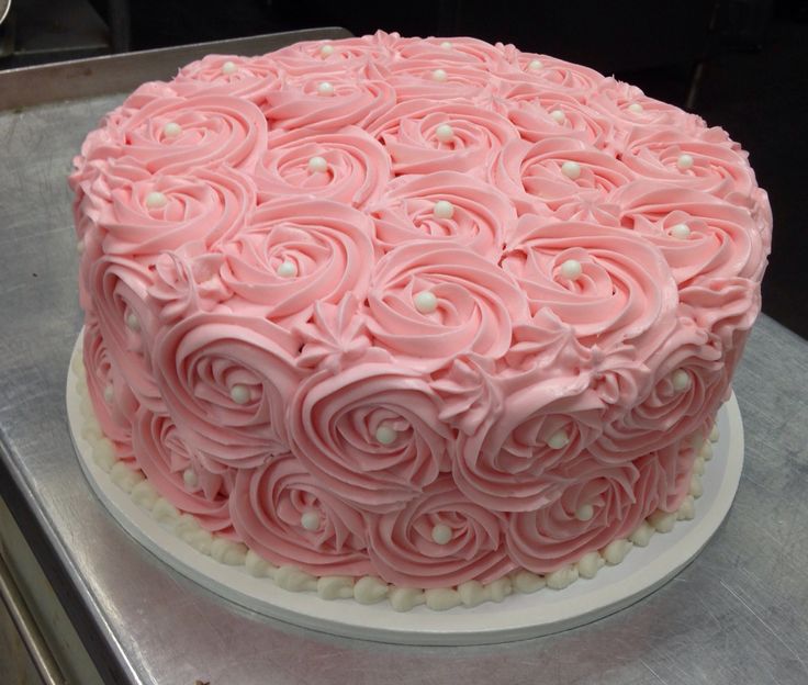 a pink frosted cake sitting on top of a counter