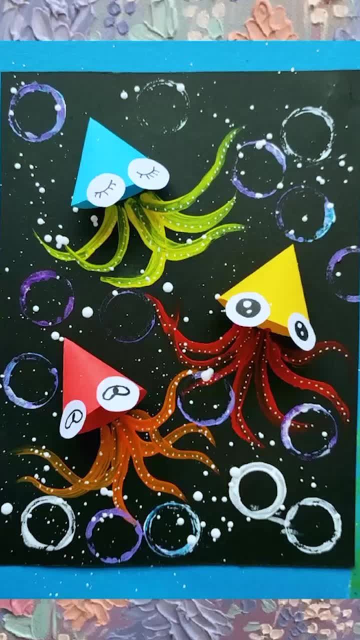 an art project with paper and scissors on top of a piece of artwork that looks like octopus