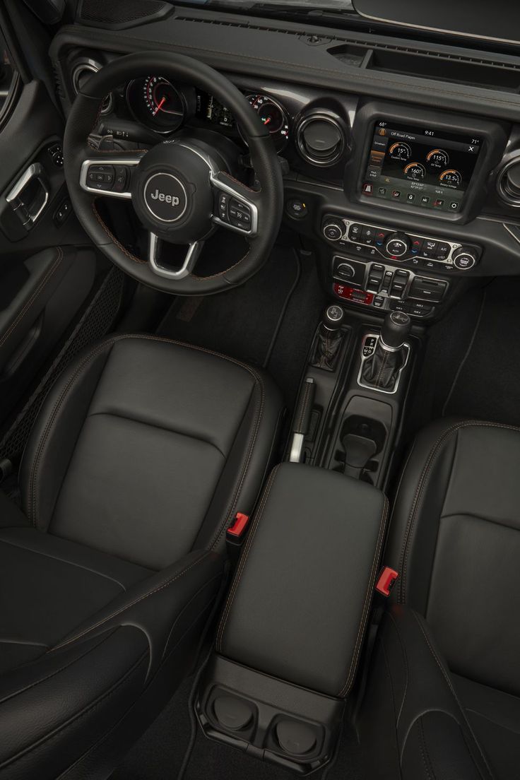 the interior of a car with black leather and red stitching on the dash panel