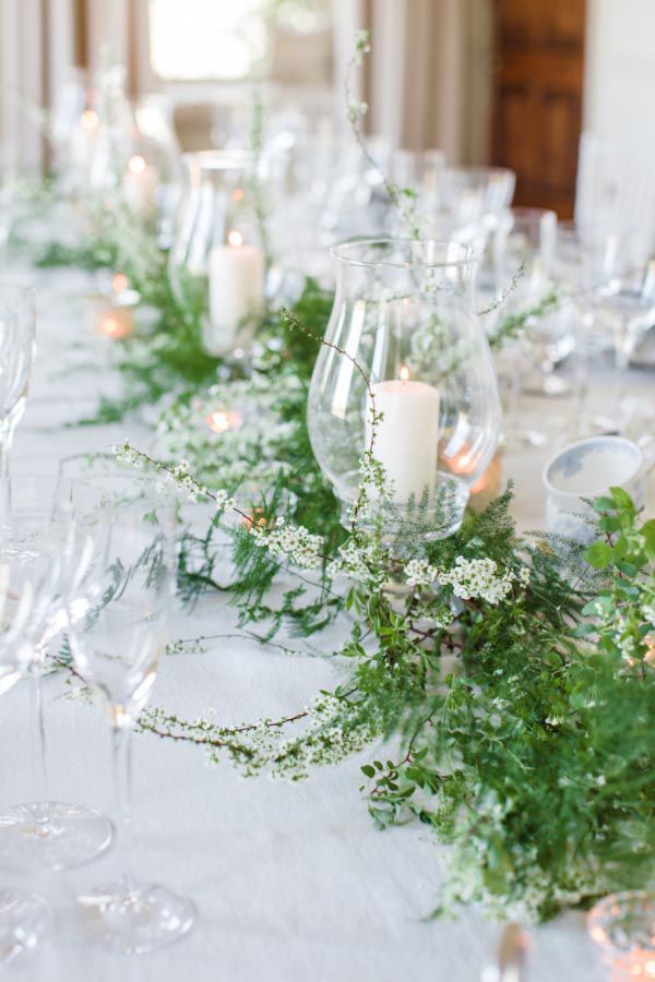 the table is set with candles and greenery