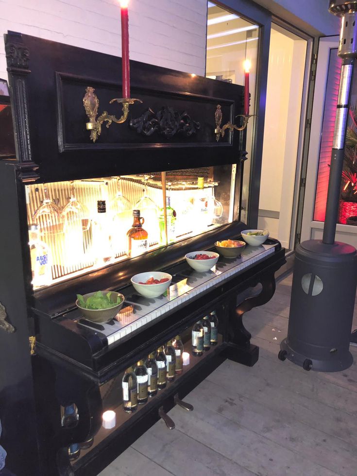 an old piano with food on it in front of a window