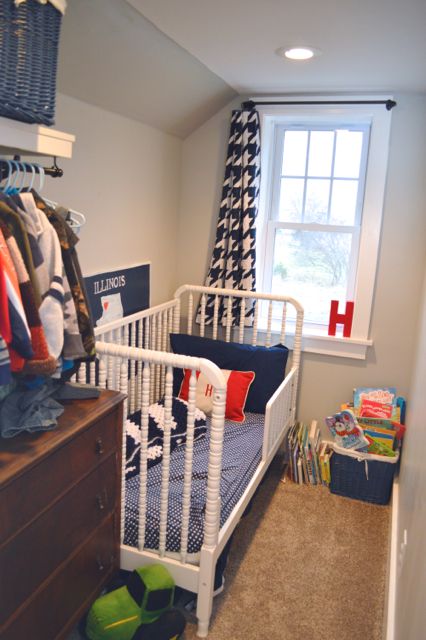 a small child's room with a bed, dresser and window in the corner