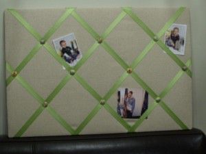 a bulletin board with pictures on it in the corner next to a black leather chair