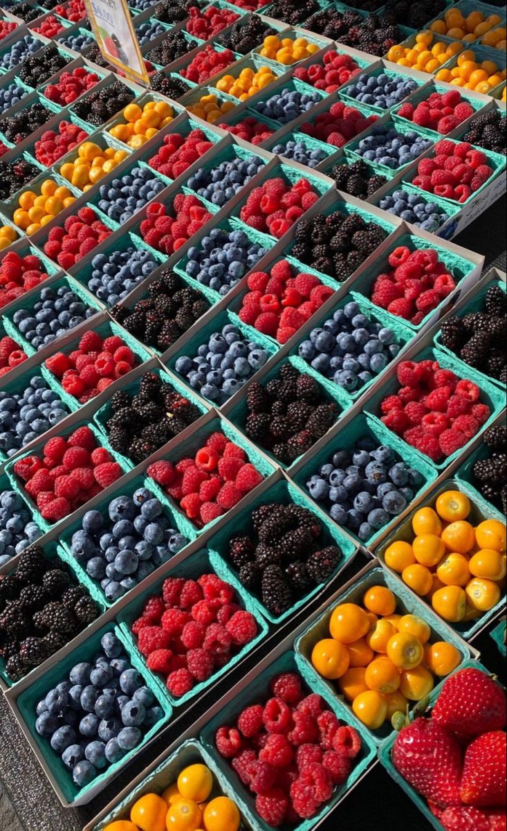 fresh berries and oranges for sale at an outdoor market