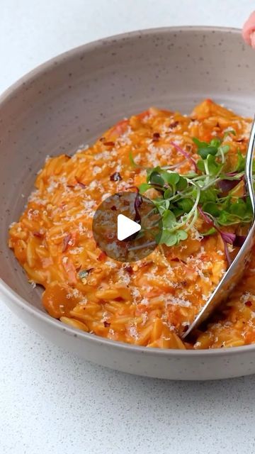 a bowl filled with pasta and garnished with parsley