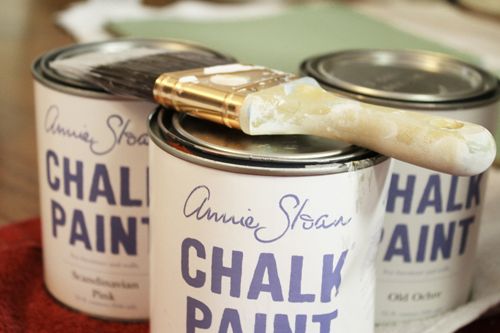 two cans of chalk paint sitting on top of a table