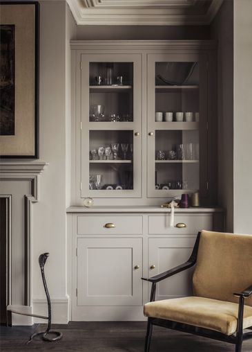 a living room filled with furniture and a fire place in front of a wall mounted fireplace