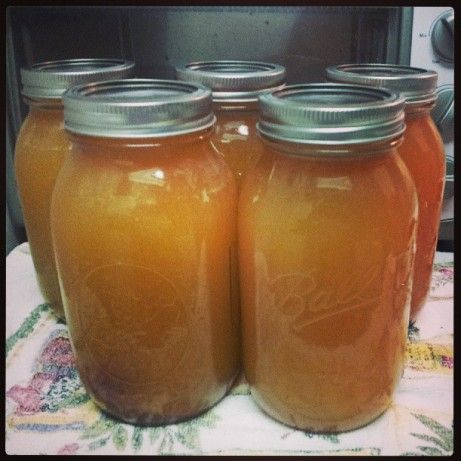 four jars filled with liquid sitting on top of a table