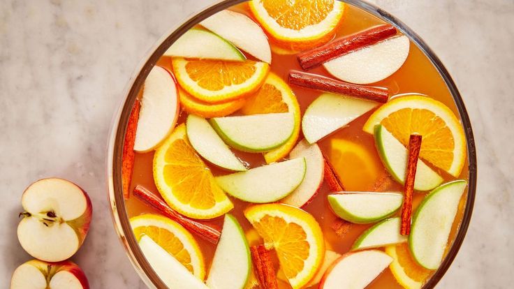 sliced apples and oranges are in a bowl