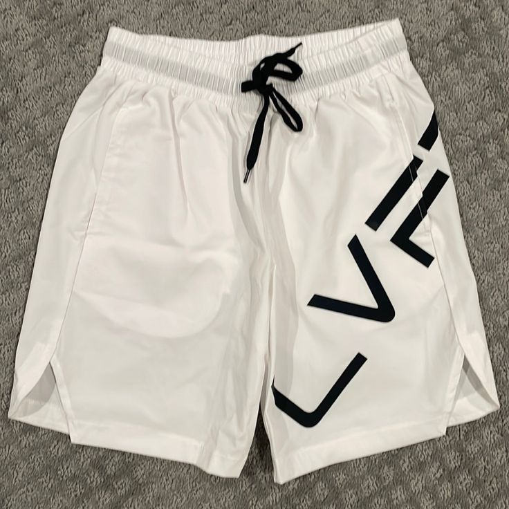 Hybrid Weatherproof Modern Silhouette 100% Polyester Side Slits For Extra Mobility Breatheable Stretch Technology Oversized Soft Touch Vinyl Lvft. Logo (2) Side Seam Pockets / (1) Back Pocket Tonal Stitching White Activewear With Built-in Shorts For Summer, White Short Athleisure Bottoms, White Stretch Beachwear Bottoms, White Short Length Athleisure Bottoms, White Short-length Athleisure Bottoms, White Athletic Shorts For Gym, White Athletic Shorts For Beachwear, White Activewear With Elastic Waistband For Gym, White Athletic Shorts For Gym In Summer