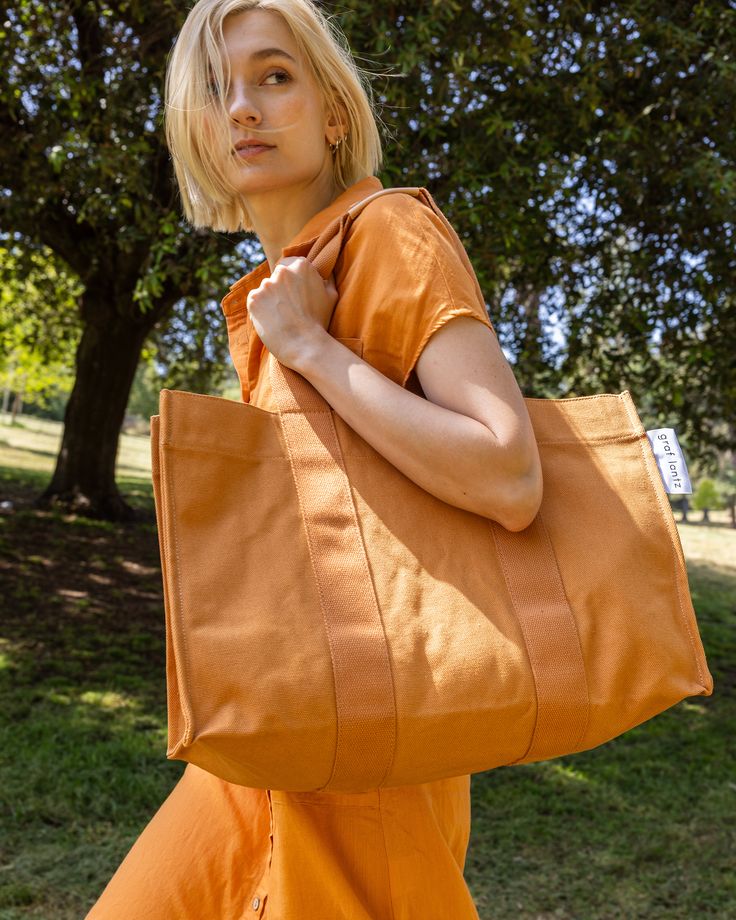 Sometimes you need a big cotton tote. For beach days, or pool days, or picnics, or last minute getaways, or shopping trips around town. Ours is of sturdy heavy cotton, with thick webbing handles, just like you, it gets the job done and looks flawless doing it. The flat bottom allows for easy packing and a magnetic closure makes getting in and out of it easy. So stack storage containers full of snacks, or fill with fresh towels ready for after that refreshing dip. Pair with the matching pouch for Travel Cotton Tote Beach Bag, Summer Large Capacity Cotton Canvas Bag, Summer Canvas Bag With Large Capacity, Orange Canvas Travel Bag, Large Capacity Cotton Tote Beach Bag, Large Capacity Cotton Beach Bag For Travel, Weekend Canvas Bag With Reinforced Handles, Casual Cotton Beach Bag For Travel, Summer Weekend Cotton Beach Bag