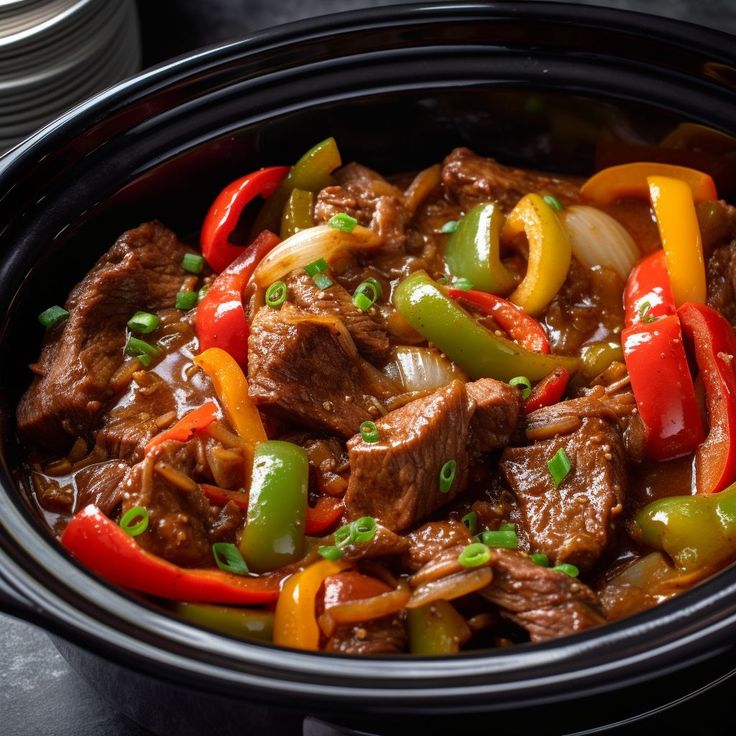 a bowl filled with beef and peppers on top of a table