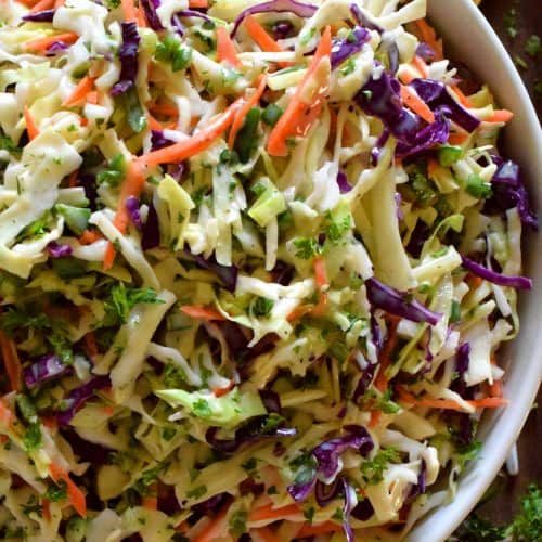 a white bowl filled with coleslaw and carrots