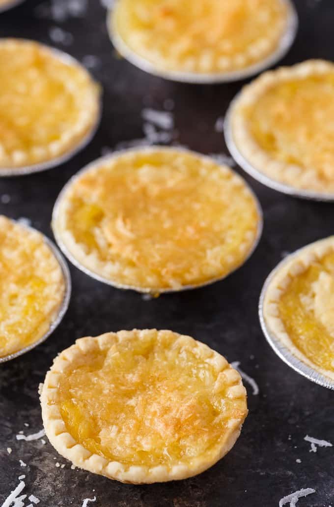 small pies are lined up on a baking sheet and ready to be baked in the oven