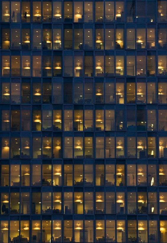 an image of a building that is lit up at night with lights on the windows