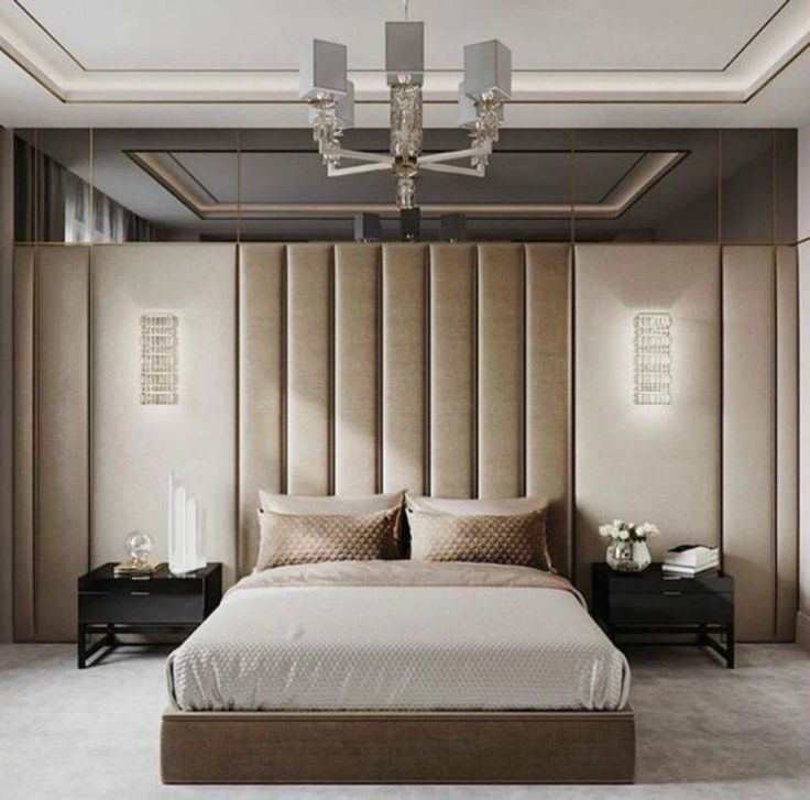 a large bed sitting in the middle of a bedroom next to a chandelier