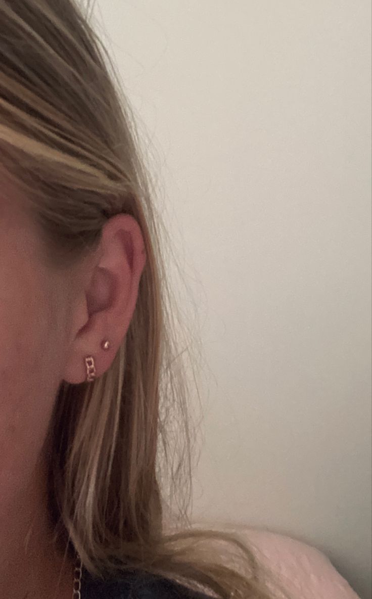 a close up of a person with ear piercings on their ears and wearing a black shirt