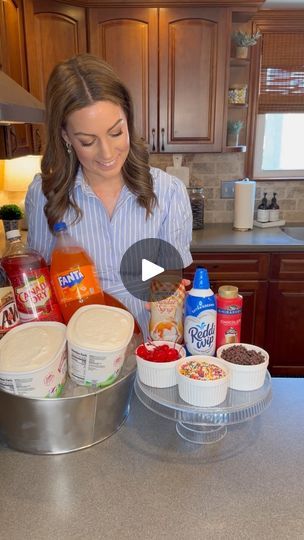 a woman standing in front of a counter filled with food and condiments on it