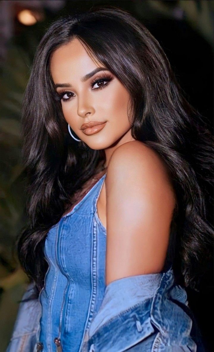 a close up of a person wearing a denim shirt and jeans on top of her head