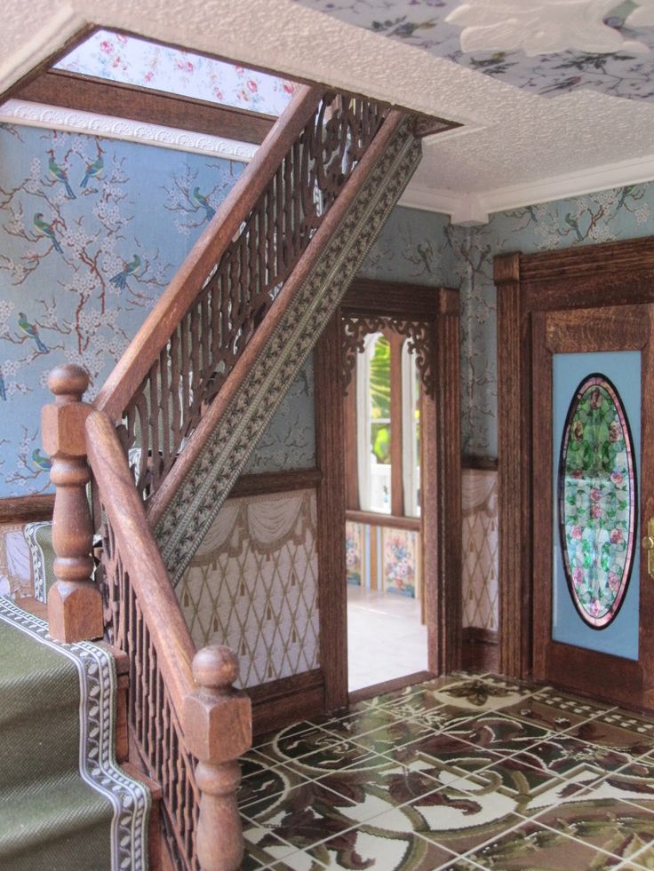 an entry way to a house with blue walls and floral wallpaper on the floor