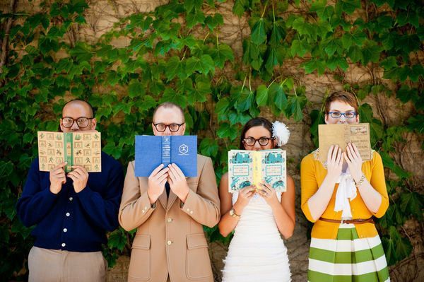 three people holding up books in front of their faces while standing next to each other