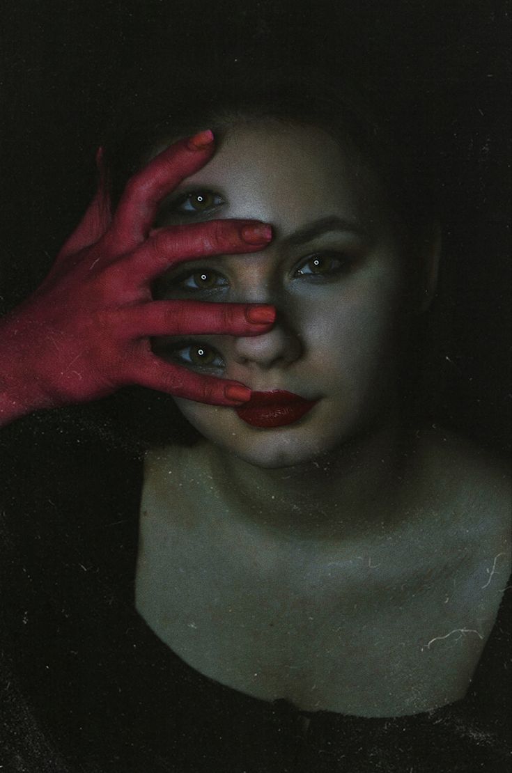 a woman with red hands covering her face